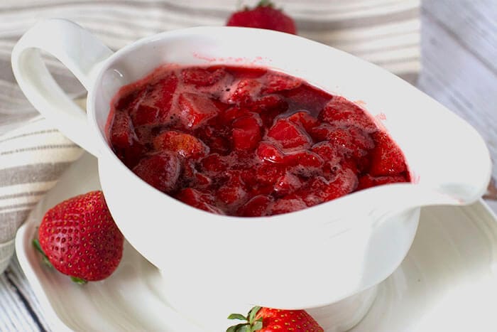 Strawberry syrup on the table in a gravy boat